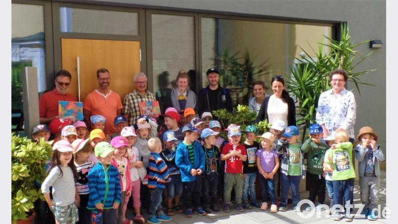 Hans Bock, Oliver Heumann und Kirchenpfleger Leonhard Steinsdörfer (hinten von links) freuen sich über die schönen Bilder, die sie für Pfarrgemeinderat und Kirchenverwaltung entgegennehmen können. Kindergartenleiterin Marion Eitel (Zweite von rechts) dankt mit ihrem Team und den Kindern. Bild: jml