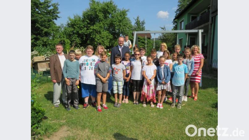 Landrat Andreas Meier übergibt die Broschüre an die Klasse 4 b der Grundschule Neustadt (Mitte), Kreisjugendpfleger Jürgen Orlik (links) Schulrätin Margit Walter (rechts) und Rektorin Heike Merther (hinten, Dritte von rechts) freuen sich über die schönen Geschichten. Bild: adj