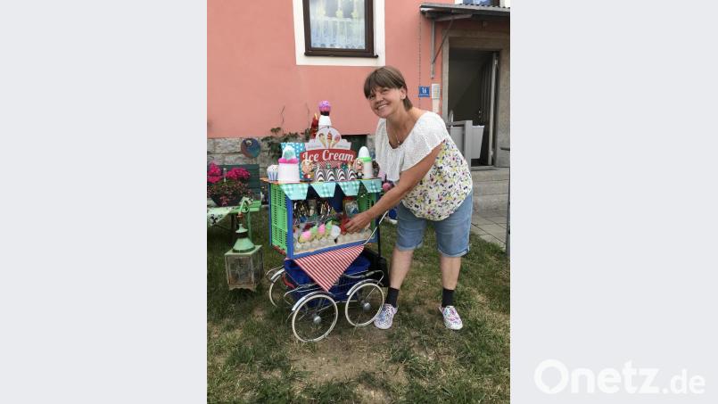 Erna Meißner und ihr Rollator, ein umgebauter Kinderwagen, den sie je nach Jahreszeit dekoriert: Im Moment hält sie sich an einem Eiswagen fest. Bild: eig