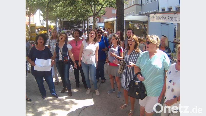 Ramona Fink und Hope &amp; Joy beim Flashmob zwischen den Marktkaufleuten. Bild: Kunz