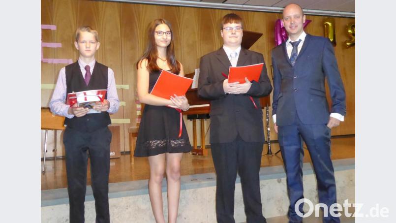 Die Prüfungsbesten in der 9. Klasse (von links): Aaron Wiebe, Jasmin Schupfner und Johann Kraus mit Klassenlehrer Tobias Stich. Bild: fsb