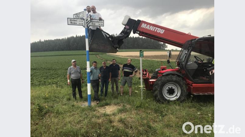 Der alte Wegweiser steht wieder, die Freien Wähler haben ihn restauriert: Günther Meißner, Hans Wittmann, Dieter Schubert, Lothar Meißner, Ernst Zilbauer (von links); oben in der Schaufel Tobias Groß (links) und Oswald Lingl. Bild: eig