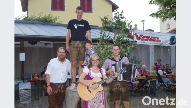 Den Kirwabaum gewann Thomas Rauch (links). Mit im Bild KlJB-Vorsitzender Florian Schmid sowie Kirwabursch Max Lindner, der das Glückslos zog. Für die passende Kirwamusik sorgten Theresa und Johannes Reis. Bild: slh