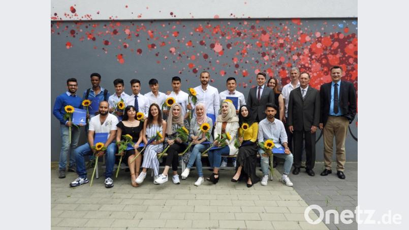 21 Schüler der Integrationsvorklasse der FOS/BOS erhalten ihre Zeugnisse des Mittleren Schulabschlusses. Hierzu gratulieren (stehend, von rechts) stellvertretender Schulleiter Jürgen Gleixner und Richard Troglauer, kommissarischer Schulleiter der Pfalzgraf-Friedrich-Mittelschule Vohenstrauß. Bild: Winkler