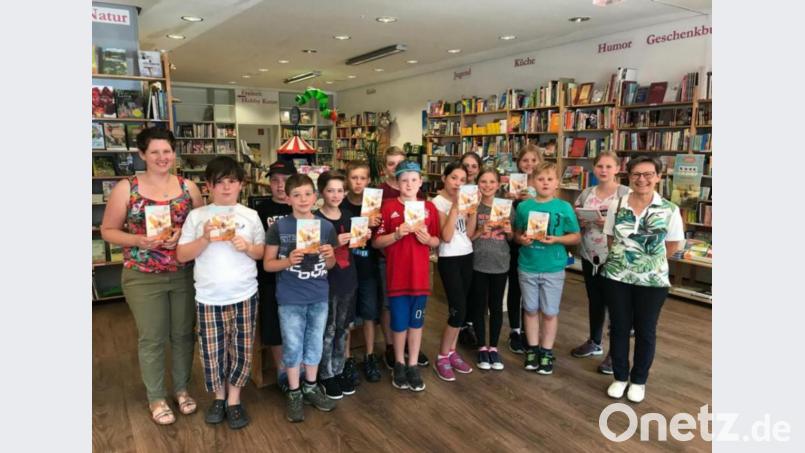 Nach der schönen Schulstunde in der Buchhandlung durften sich die Kinder mit ihrer Rektorin Gabriele Achmann (rechts) auch noch über ein Buchgeschenk freuen, das ihnen Stefanie Teicher (links) überreichte. Bild: ubb