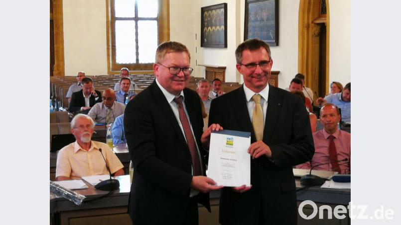 Oberbürgermeister Michael Cerny (links) übergibt Stadtwerke-Chef Stephan Prechtl die Urkunde zum Beitritt in den Umweltpakt Bayern. Bild: ass