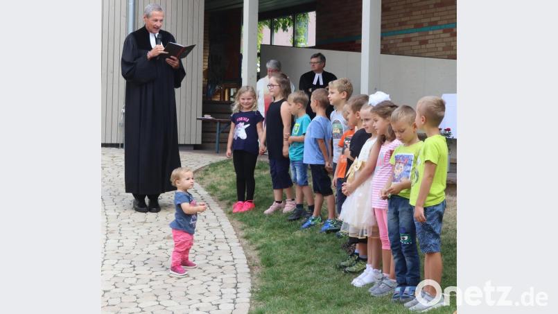 Pfarrer Uwe Markert segnet die Vorschulkinder und überreicht ihnen ein hölzernes Kreuz als Andenken an die Kindergartenzeit. Bild: mfh