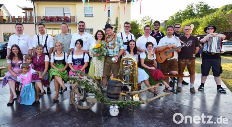 Die ehemaligen Kirwapaare nach dem Austanzen am Montag. Mit Wurstkranz und Blumenstrauß schmückt sich das Oberkirwapaar Susanne und Michael Honig (Mitte); mit im Bild die Kirwamusikanten. Bild: no