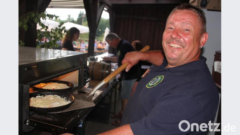 Karl &quot;Luigi&quot; Bauer mit einer Forellenpizza, dem Renner beim Fischerfest. Bild: kro