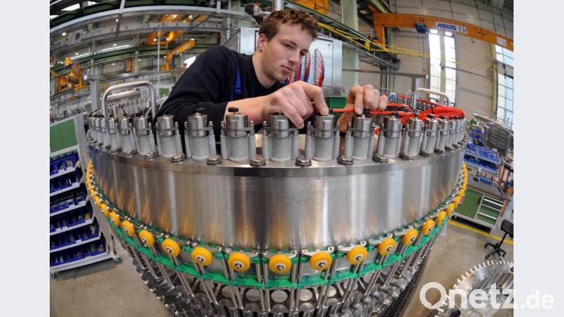 Ein Mitarbeiter der Krones AG arbeitet an einer Getränke-Abfüllanlage im Werk Neutraubling. Bild: Armin Weigel/dpa