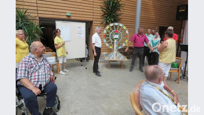 Beim „Glücksrad“ treten Pfarrer Dirk Grafe (Mitte) und zweiter Bürgermeister Hermann Schraml (rechts davon) gegeneinander an. Dabei gewinnt der Seelsorger. Vielleicht dank himmlischer Unterstützung? Bild: jzk