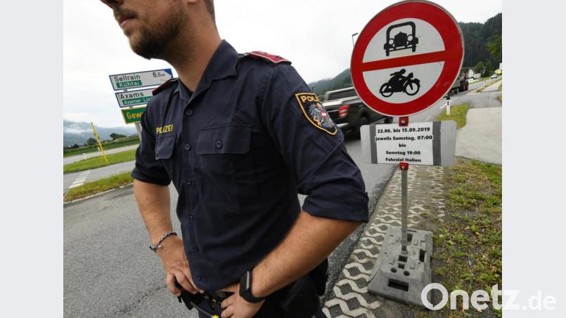 Ein österreichischer Polizist steht vor einem Schild, das auf die Sperrung für den Verkehr mit Fahrziel Italien hinweist. Bild: Angelika Warmuth/dpa