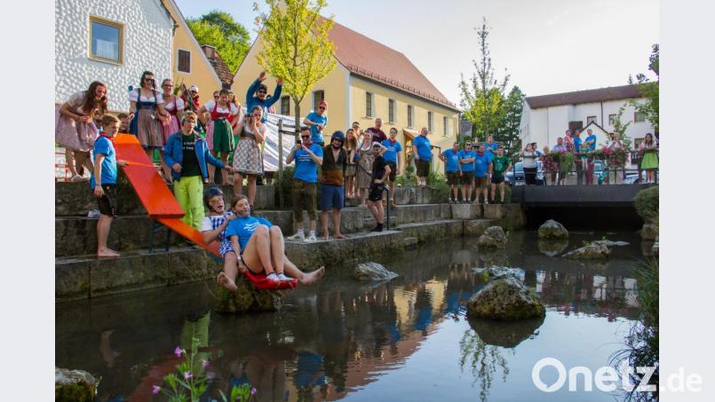 Der Umzug der Kirwapaare am Montag endet traditionell am – beziehungsweise im – Etzelbach. Neu ist heuer allerdings die in Leichtbauweise errichtete Rutsche, auf die sich nur die Wagemutigsten hinauftrauen. Bild: Christian Skiefe