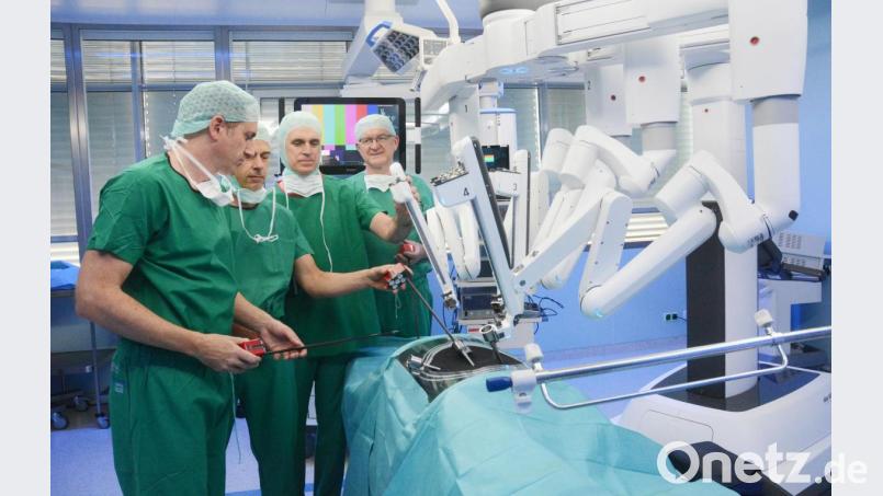 Vier Chirurgen freuen sich über vier verlängerte Arme. Thomas Bschleipfer, Martin Sonnek, Theo Klotz und Karl-Heinz Dietl (von links) sind begeistert vom neuen OP-Roboter am Klinikum Weiden. Bild: Gabi Schönberger