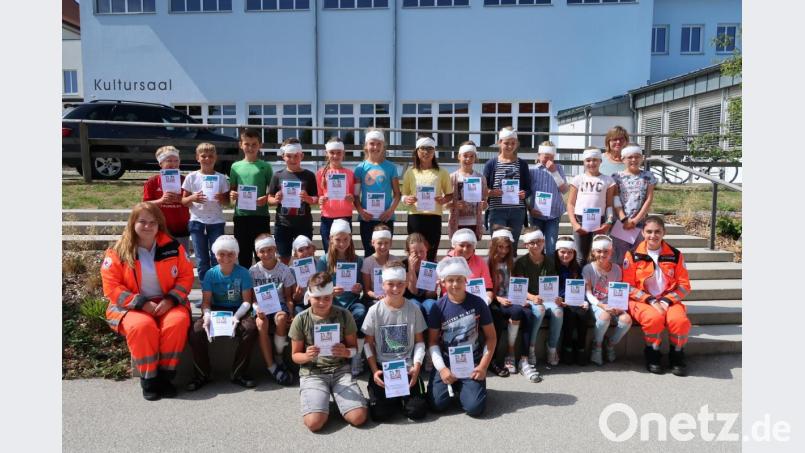 Ausgestattet mit einem Notfallset zum Üben und mit einer Urkunde „Juniorhelfer“ stellten sich alle Teilnehmer mit den beiden Übungsleiterinnen und der Klassenlehrerin Irmgard Wittmann zu einem Foto im Schulhof auf. Bild: exb