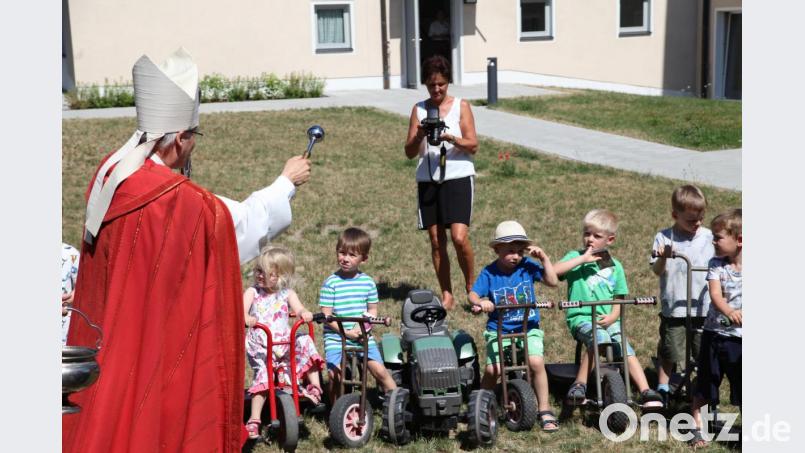 Auch das gibt es: Anlässlich des Tages des heiligen Christopherus, dem Schutzpatronen aller Reisenden, segnet Bischof Rudolf Voderholzer die Fahrzeuge der Kinder im Schirmitzer Kindergarten. Bild: Diözese Regensburg