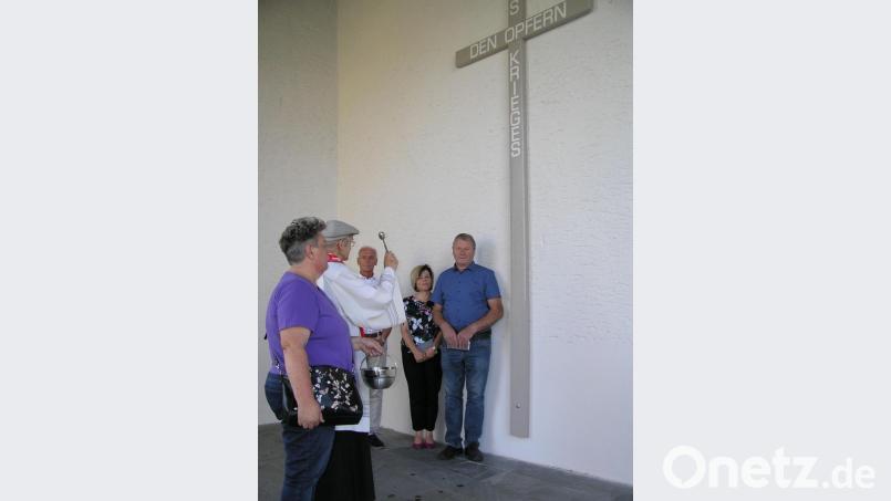 Das renovierte Gedenkkreuz für die Kriegsopfer segnete Pfarrer Hans Riedl (Zweiter von links) im Beisein von Kirchenpfleger Hans Richtmann (von rechts) und den Mitgliedern der Kirchenverwaltung Gabi Herrmann, Bürgermeister Peter König und Maria Riedl. Bild: öt