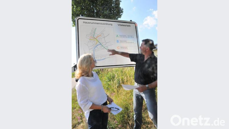 Zweite Bürgermeisterin Andrea Lang und Bürgermeister Rainer Rewitzer präsentieren eine neue Ortseingangstafel in Vöslesrieth, die auf die örtliche Lage der Anwesen und Wohnhäuser mit ihren Hausnummer hinweist. Bild: bey