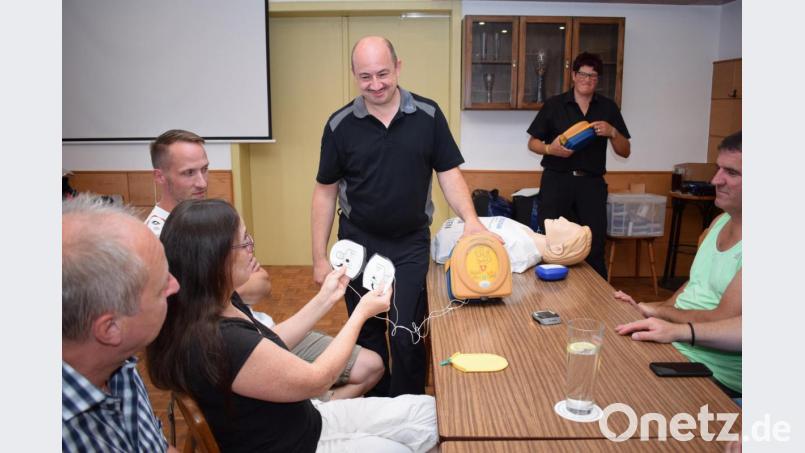 Marko Frischholz zeigt den Sportfunktionären den richtigen Umgang mit einem Defibrillator. Bild: bnr