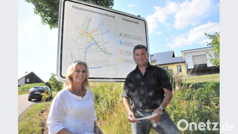 Zweite Bürgermeisterin Andrea Lang und Bürgermeister Rainer Rewitzer präsentieren eine neue Ortseingangstafel in Vöslesrieth, die auf die örtliche Lage der Anwesen und Wohnhäuser mit ihren Hausnummer hinweist. Bild: bey