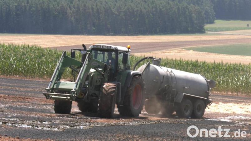 Mit Wasser aus Güllefässern löschen Landwirte ein brennendes Stoppelfeld ab. Bild: rw
