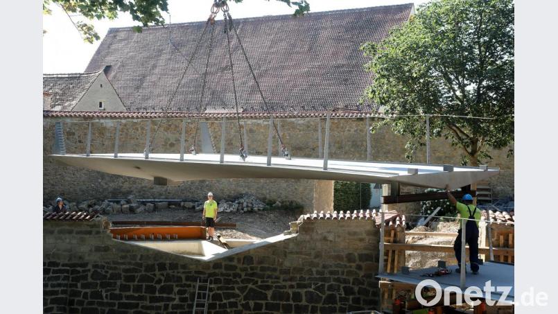 Der erste Teil des neuen Pionierstegs ist schon eingebaut, jetzt schwebt der zweite ein. Für den großen Kran im Stadtgraben war es ganz schön eng, vom Kranführer Präzisionsarbeit gefragt. Bild: Wolfgang Steinbacher