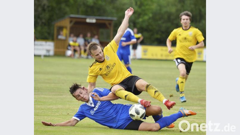 Der Schwarzhofener Innenverteidiger Christian Weiss (unten) grätscht auf Kosten eines Freistoßes den von der DJK Ammerthal zu seinem Stammverein zurückgekehrten Hahnbacher Siegtorschützen Tobias Hüttner ab. Bild: Hubert Ziegler