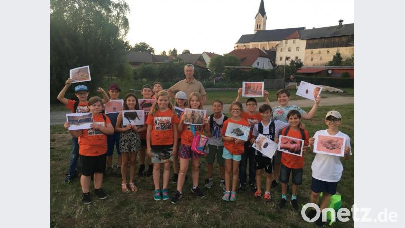 Bei einer spannenden Fledermausführung passen die Viertklässler gut auf und erhalten eine Urkunde. 
Fledermausexperte Markus Liebl (hinten) hat den Schülern einen spannenden Abend beschert. Bild: sei