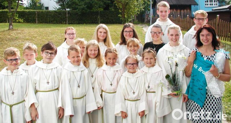 Noch vor dem Gottesdienst überreichte Oberministrantin Eva Glowka (mit Blumen) im Namen der Ministranten Geschenke, unter anderem ein T-Shirt mit allen Namen. Bild: ld