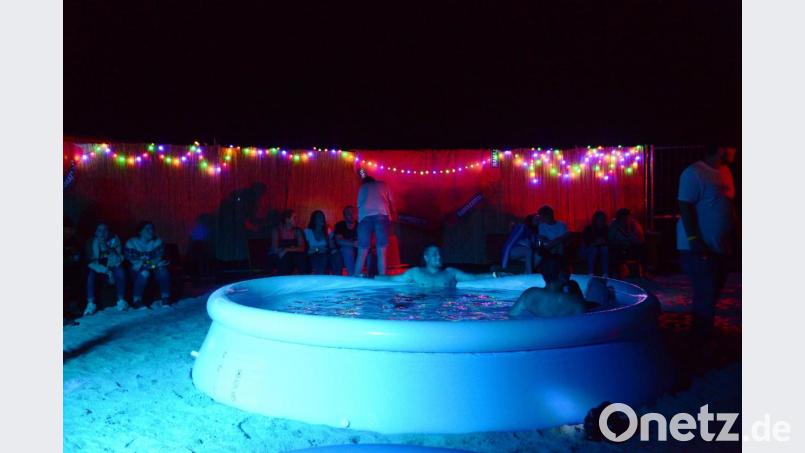 Eine Beach-Party ohne Sand und Wasser eigentlich unmöglich. Die Organisatoren der Beach-Party der SpVgg Schirmitz haben eine ordentliche Fuhre Sand abgeladen, dazu einen Mini-Swimmingpool aufgeblasen und fertig war das Mittelmeerfeeling mit dem bunten Lichtern im Hintergrund. Bild: bey