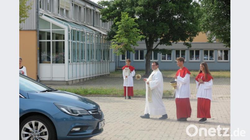 Nach dem Sonntagsgottesdienst segnet Stadtpfarrer Konrad Amschl die Fahrzeuge auf dem Schulplatz. Bild: jzk