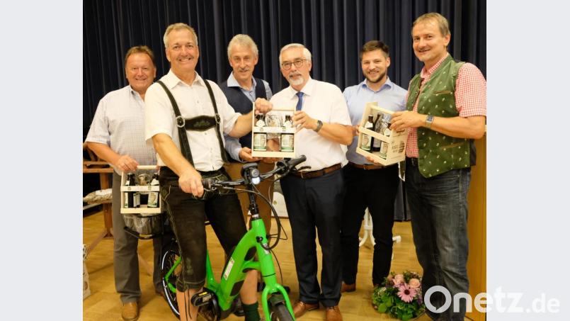 Ein neues &quot;Gemeindefahrzeug&quot; in Form eines umweltfreundlichen E-Bikes und flüssige Grüße von der &quot;Weltgrößten Holzkugel&quot; hatte die Schwarzenfelder Delegation mitgebracht. Auf dem Bild die Bürgermeister mit ihren Vertretern bei der Überreichung. Bild: mab