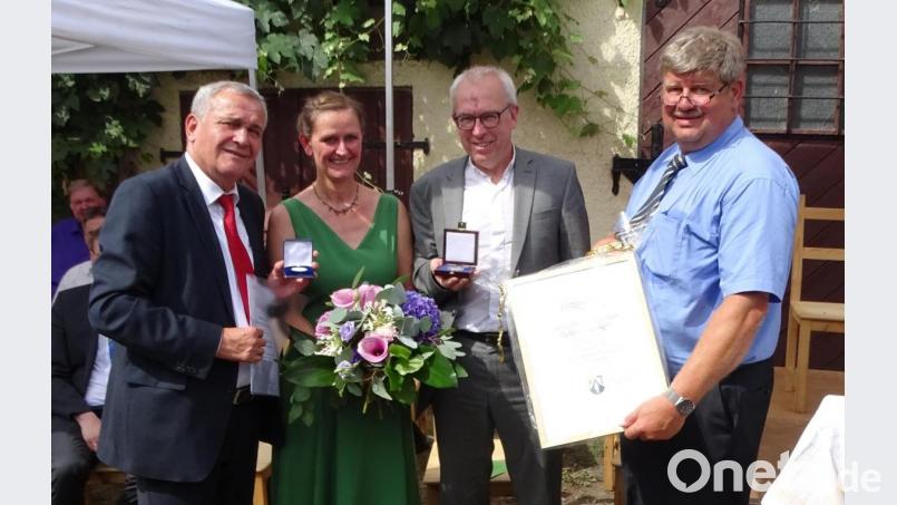 Die Silberne Bürgermedaille der Stadt Weiden überreicht OB Kurt Seggewiß (links) und die Goldene Bürgermedaille mit Urkunde der Gemeinde Etzenricht händigt Bürgermeister Martin Schreglmann (rechts) an Pfarrer Hans-Peter Pauckstadt-Künkler aus. Blumen gibt es für Ehefrau Sigrid Künkler. Bild: Dobmeier