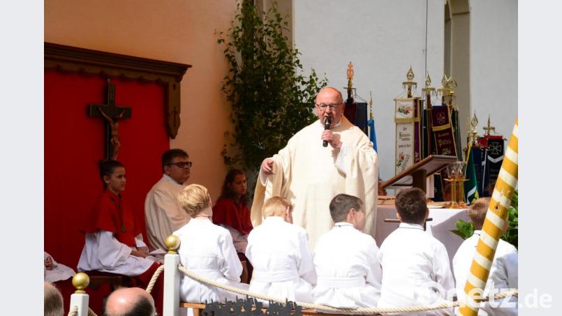 Pfarrer Wilhelm Bauer spricht in Richtung der Ehrengäste. Bild: bey