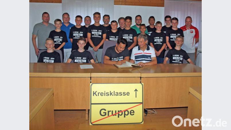 Die A-Jugend trug sich mit Hans Fischer (stehend, links), Vorsitzender des 1. Rieden, Gerhard Härtl (stehend, rechts), Jugendleiter des SV Vilshofen, samt Betreuern im Beisein von Zweitem Bürgermeister Josef Weinfurtner (sitzend, Zweiter von rechts) ins goldene Buch des Marktes Rieden ein. Bild: sön