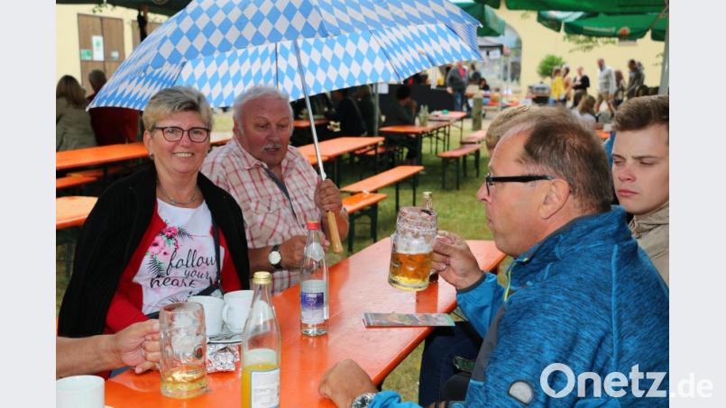 Als Regen einsetzte, nutzten die Gäste Regenschirme und die großen Sonnenschirme als vorübergehenden Unterschlupf. Bild: bsc