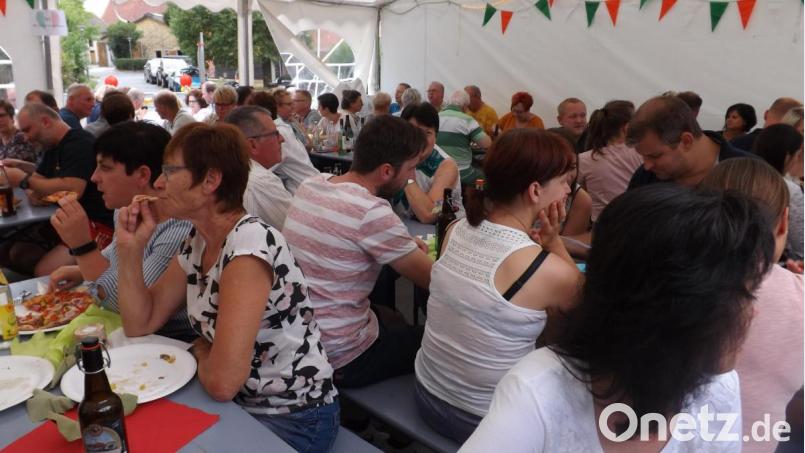 Viele Besucher drängen sich im italienisch geschmückten Pavillon am Dorfbackofen. Bild: trj
