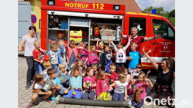 Die Lintacher Kinder mit der stellvertretenden Kindergartenleiterin Andrea Dobmeier (links) besuchen die Feuerwehr. Brandschutzerzieher Tobias Göbl (hinten rechts) stellt ihnen die Ausrüstung vor. Bild: gto