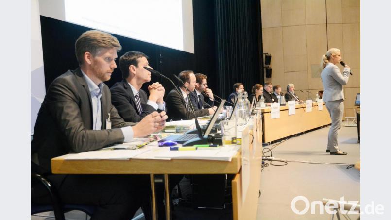 Die Vertreter der Bundesnetzagentur (links) mit Verhandlungsleiterin Janine Haller (stehend) und den Vertretern von Tennet (im Hintergrund) bei der Erörterung in der Max-Reger-Halle. Bild: Gabi Schönberger