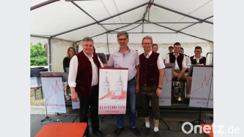 Notenüult-Banner im Wert von knapp 400 Euro für die Klosterbläser übergibt Spender Johann Mayer (Mitte) an Chefdirigent Pater Adrian Kugler (links) und Sprecher Christian Gebhardt. Bild: do