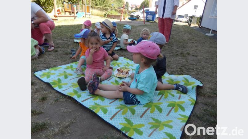 Den Kindern aus Altenstadt und Floss schmeckt die gemeinsame Brotzeit auf der Picknickdecke bestens. Sie genießen ihren Ausflug in die Gastkrippe. Bild: adj