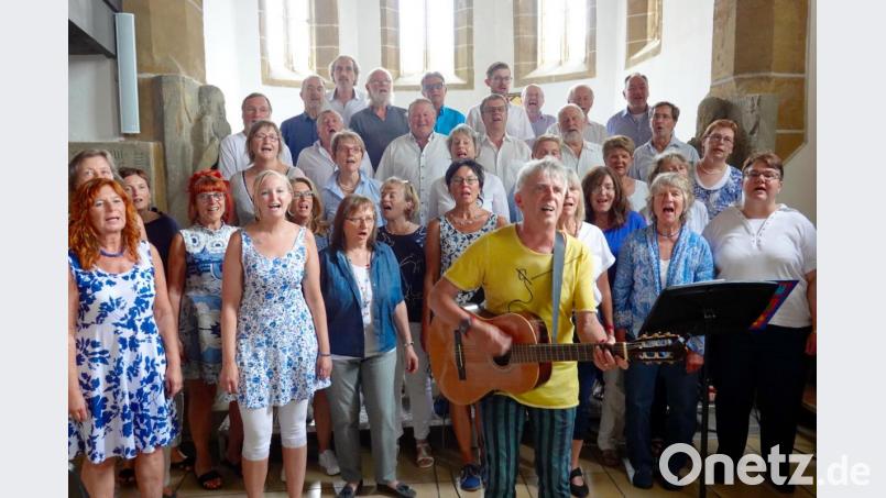 Chorleiter Franz Xaver Reinprecht spielt bei einigen Liedern genauso engagiert Gitarre wie er den Multichor leitet. Bild: gac