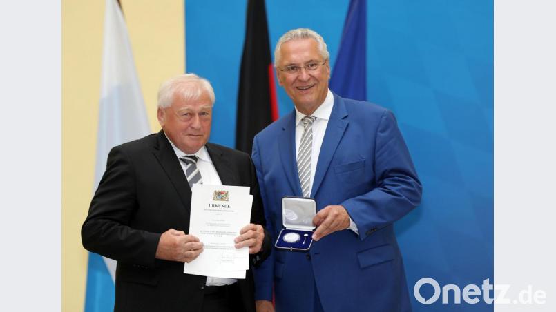 Innenminister Joachim Herrmann (rechts) überreicht Bürgermeister Johann Wilhelm (links) die kommunale Verdienstmedaille. Bild: exb