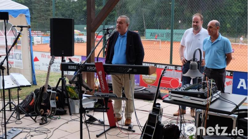 Hinter ihm ein Teil der Tennisplätze, vor ihm die Gäste der 90-Jahr-Feier des TC Grün-Rot. Dann schlägt Oberbürgermeister Kurt Seggewiß verbal auf. Dahinter stehen (von links) zweiter Vorsitzender German Schieder und Vorsitzender Marcelo Matteucci. Bild: pmö