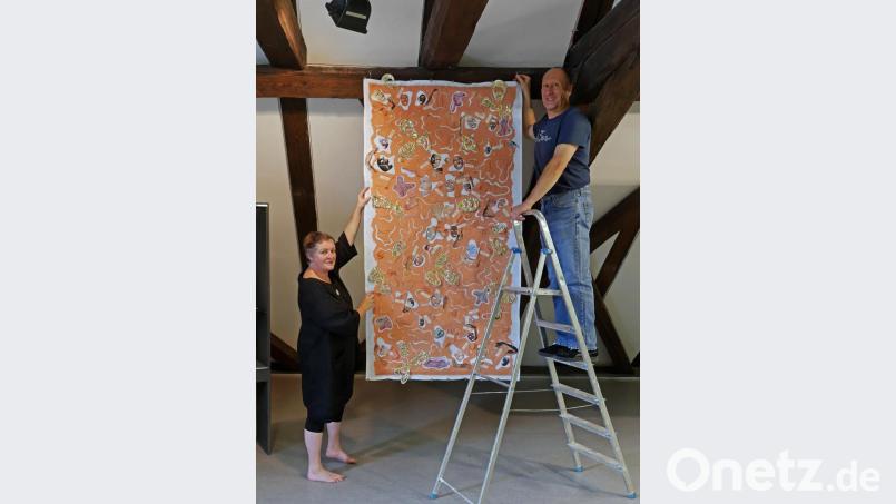 Den Artquilt „Haut(e) Couture“ hängen Jutta und Herbert Kohlbeck gemeinsam auf. Bild: tr
