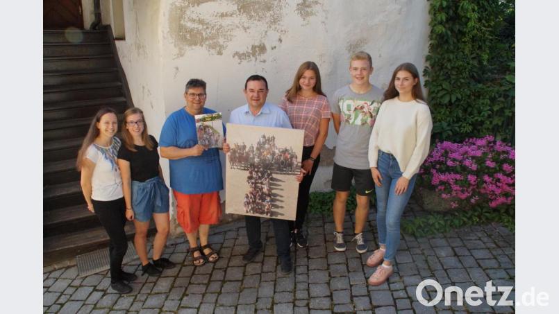Die Oberministrantinnen Jennifer Zapf und Alina Hierlein, Gemeindereferent Jochen Gößl sowie die Gruppenleiter Anna Schicker, Vinzenz Schöcklmann und Maria Nickl (von rechts) verabschieden sich mit einem Fotobuch und einer Leinwand von Pfarrer Konrad Amschl. Bild: kaz