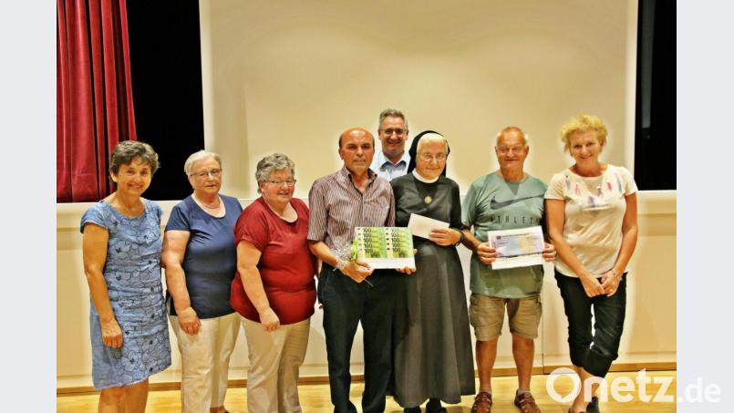Schwester Eobarda Ries konnte sich beim afrikanischen Abend im Jugendwerk über drei großherzige Spenden freuen. Für den Kapellenverein Legendorf überreichte Rudolf Birner (Vierter von links) 1000 Euro in bar. Die Senioren der Pfarrei Nabburg spendeten 400 Euro. Den symbolischen Scheck überreichten Agnes Hartauer (Zweite von links) und Herbert Bindl (Zweiter von rechts). Der Katholische Frauenbund Nabburg unterstützt die Arbeit in Nkandla mit 1000 Euro, überreicht von der Vorsitzenden Christa Schlagenhaufer (links). Bild: bph