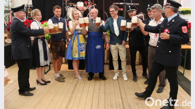 Schirmherr Georg Köppl (mit Schürze) stößt mit Alois Plößl (rechts daneben), Bierprinzessin Lena (links daneben), den Verantwortlichen der Feuerwehr und stellvertretendem Landrat Jakob Scharf (Zweiter von rechts) auf das 125-jährige Gründungsfest der Feuerwehr Fronhof an. Bild: ral