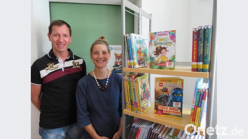 Das Sommerferien-Leseclub-Team, Patrizia Spörl und Johannes Klug, zeigt das Foto vor den 100 extra für die Aktion angeschafften Büchern. Bild: exb