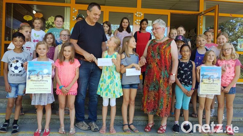 Die Einnahmen aus dem Musical überreichen die Kinder an Musikschulleiter Wolfgang Ziegler und Rektorin Ulrike Uhlemann. Bild: gi